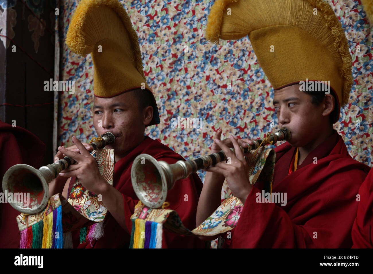 Monks in the Chiwang monastery courtyard play doublereed instruments