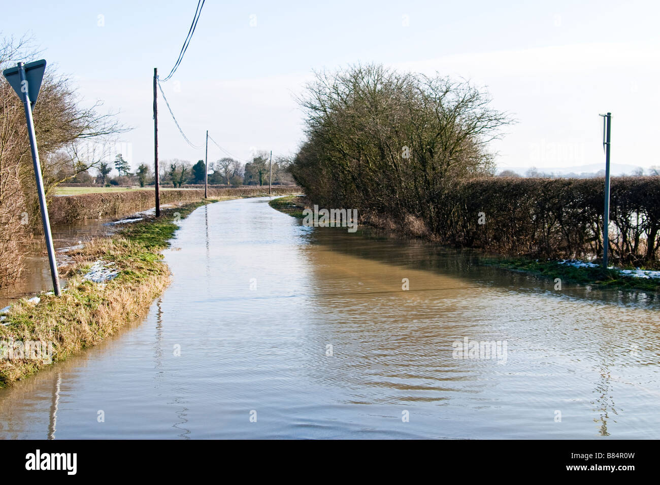 Country road under water following recent flash flooding caused by snow melt Stock Photo