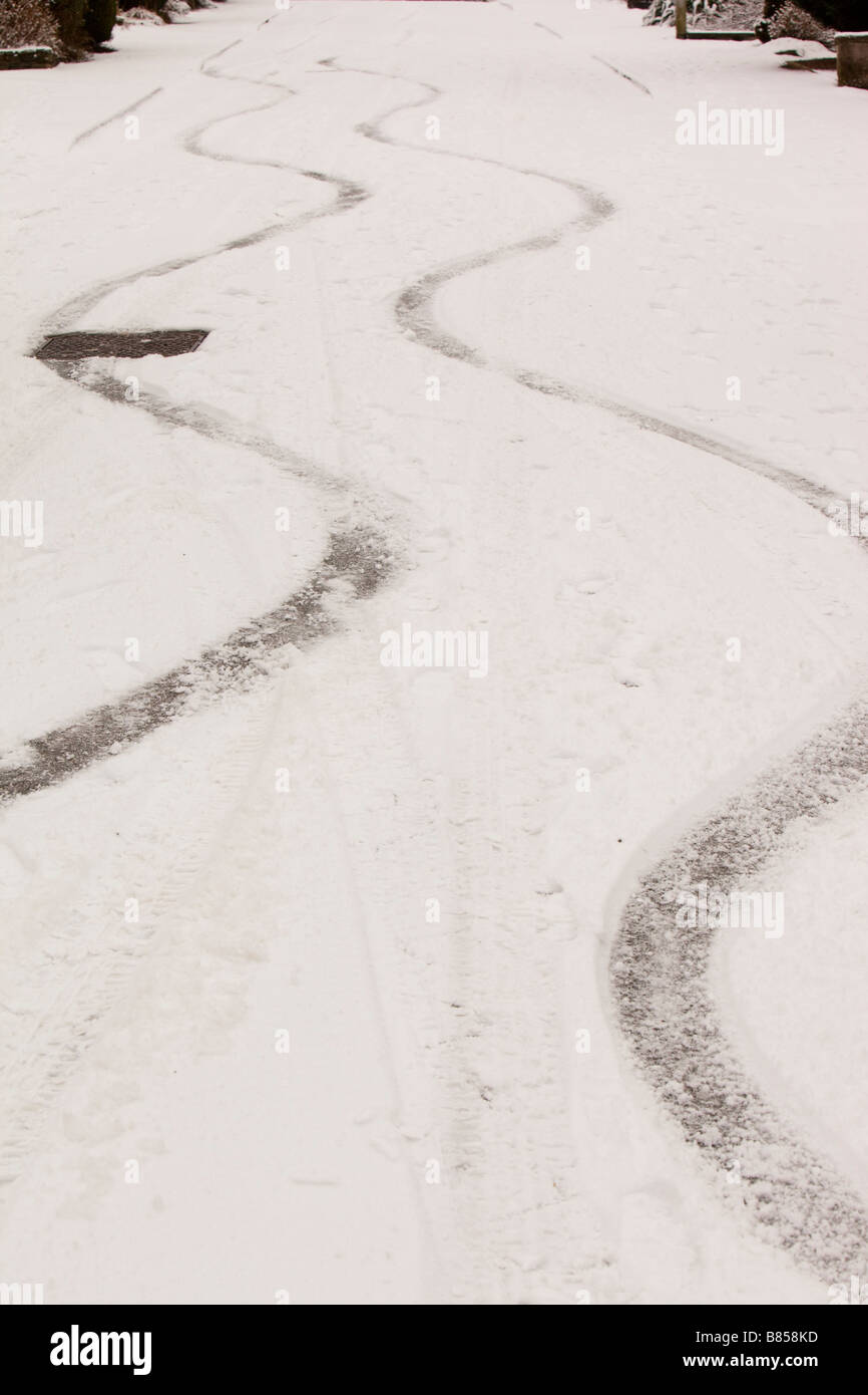 Skid marks in the snow from a car on a steep road in Ambleside UK Stock