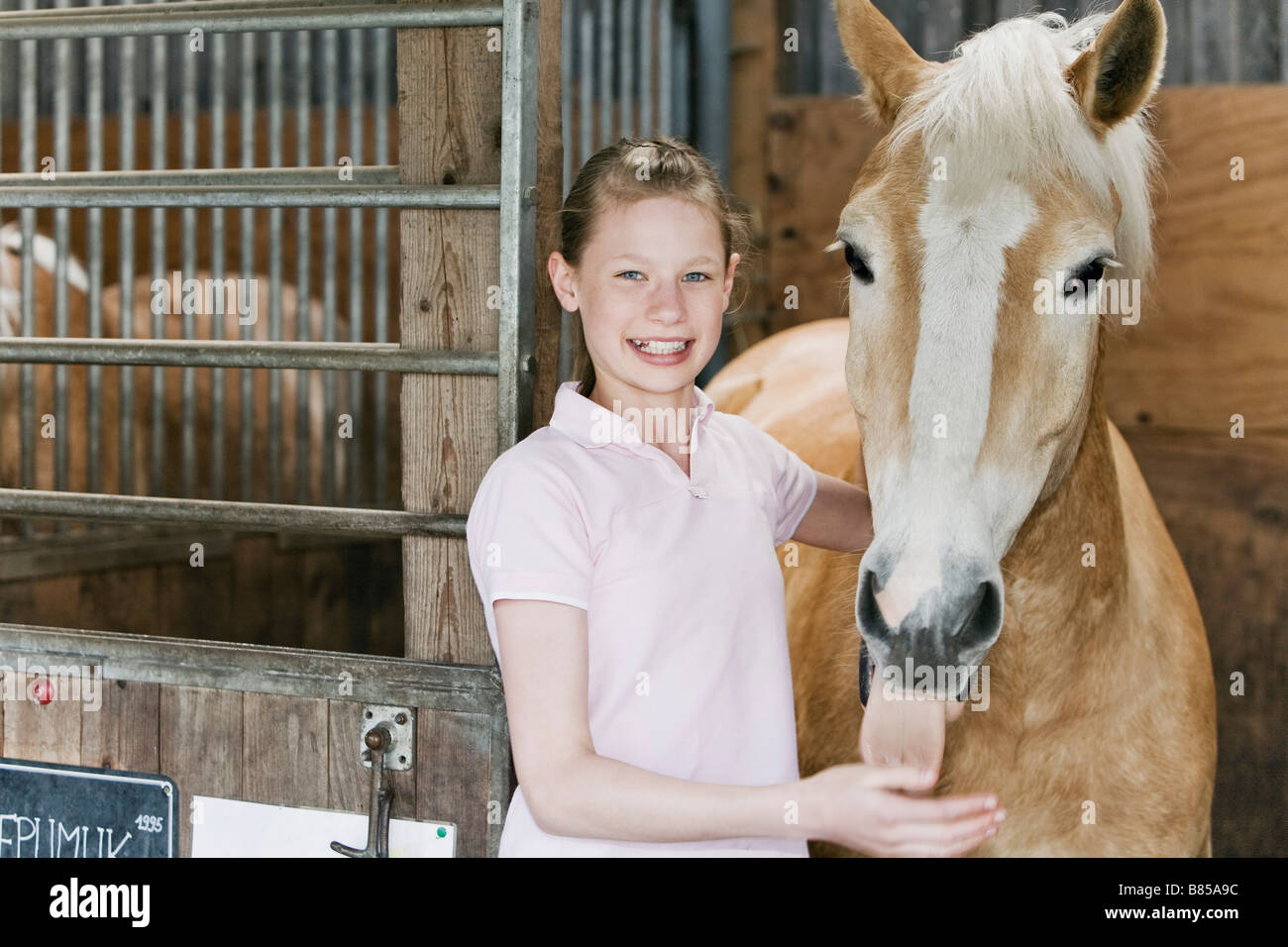 portrait of young girl with horse in stable Stock Photo