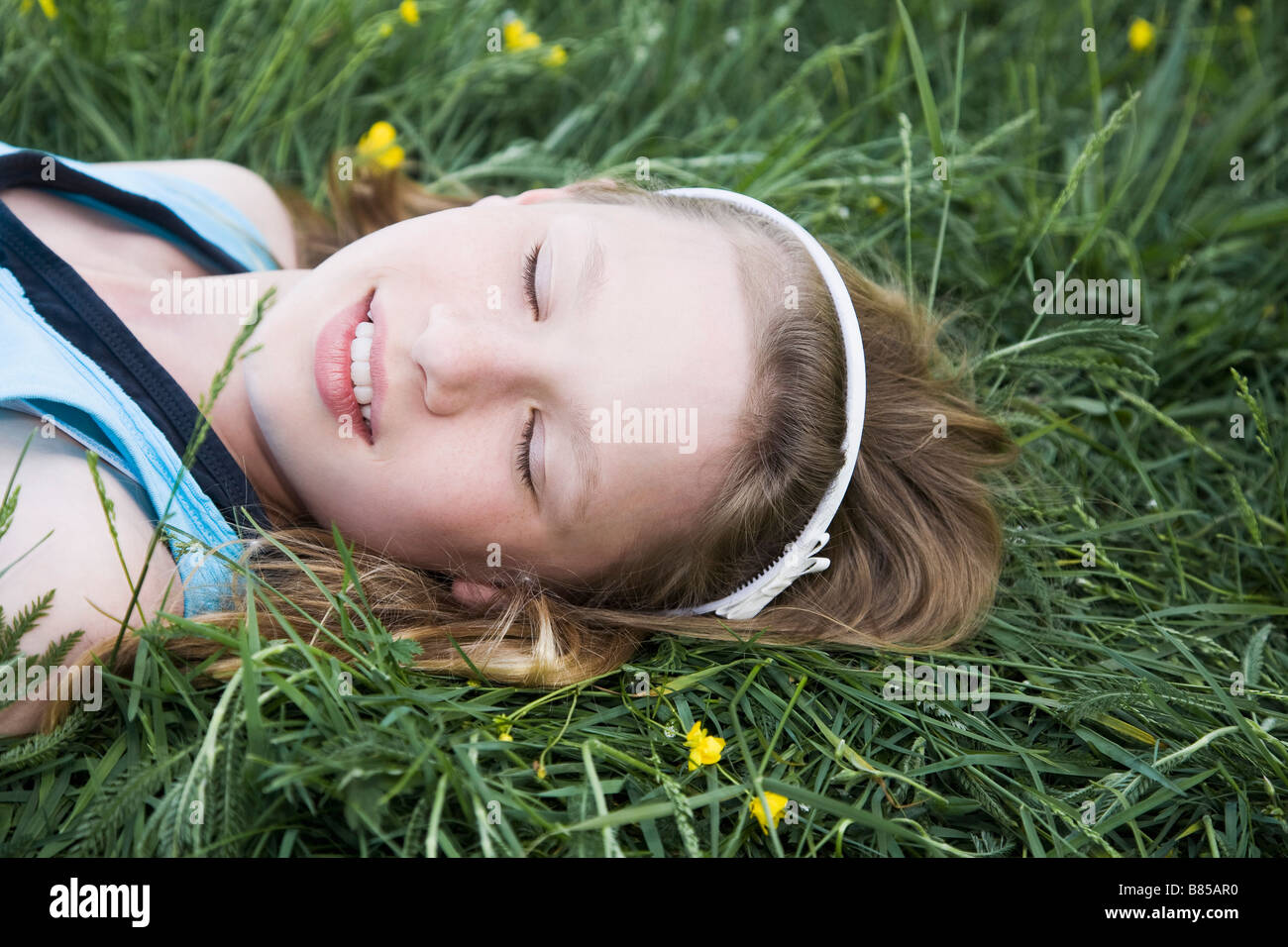 portrait of young girl lying in grass dreaming Stock Photo - Alamy