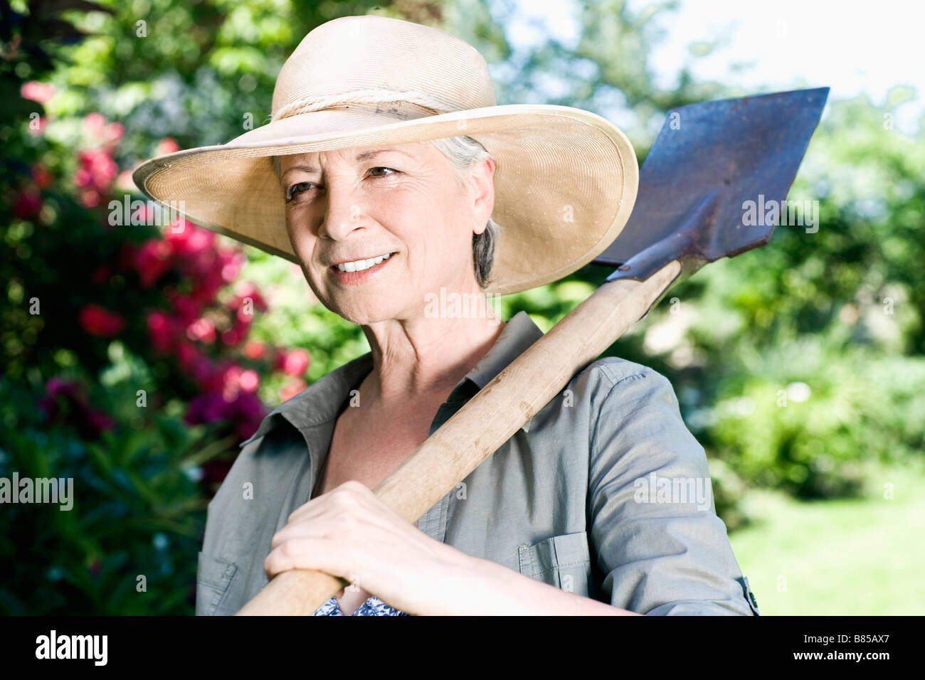 Portrait Of Mature Woman In Gardening Outfit Carrying Spade Stock Photo Alamy