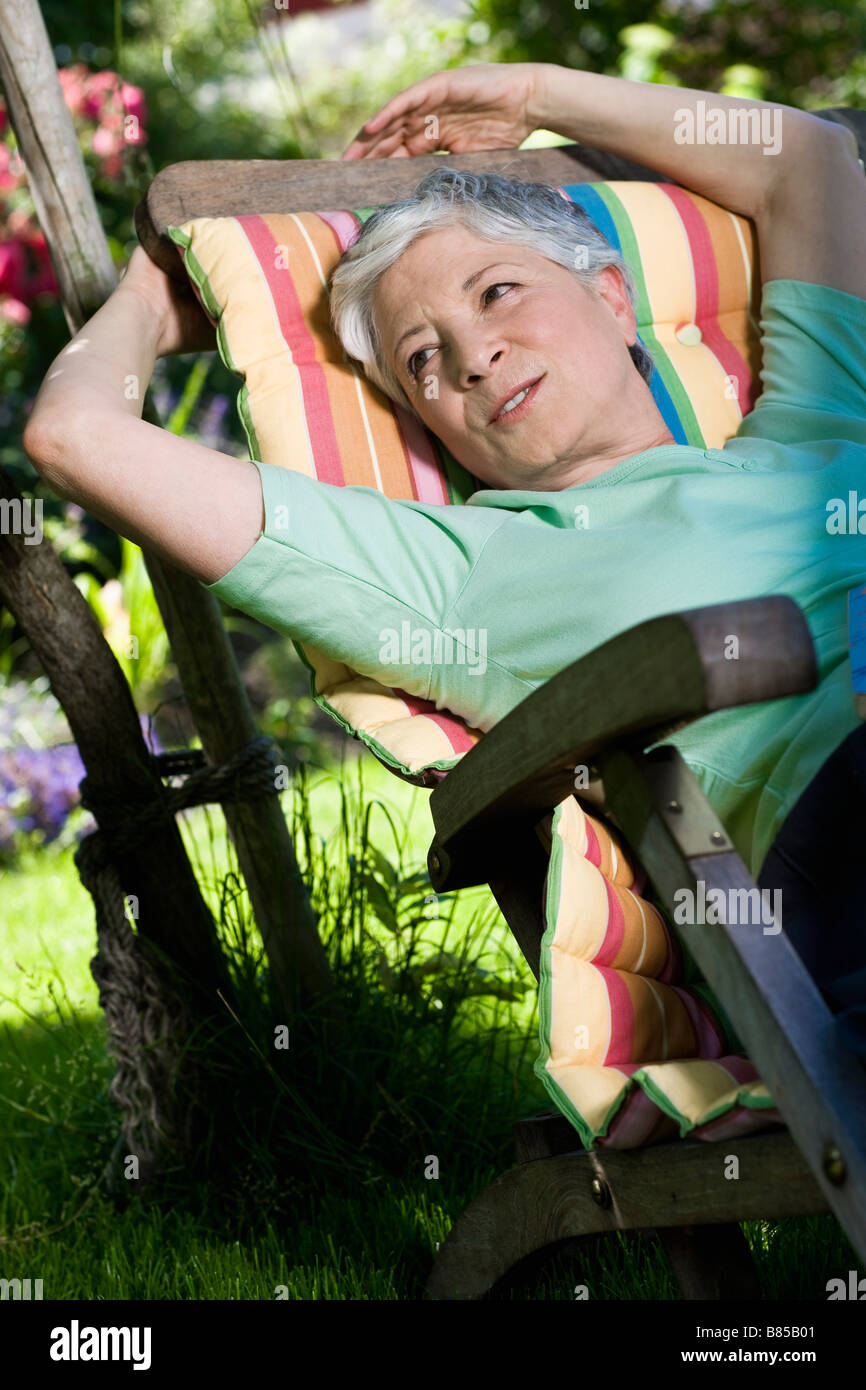 mature woman relaxing on deck chair in garden Stock Photo - Alamy