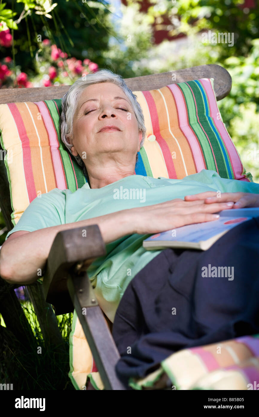 mature woman relaxing on deck chair in garden Stock Photo - Alamy