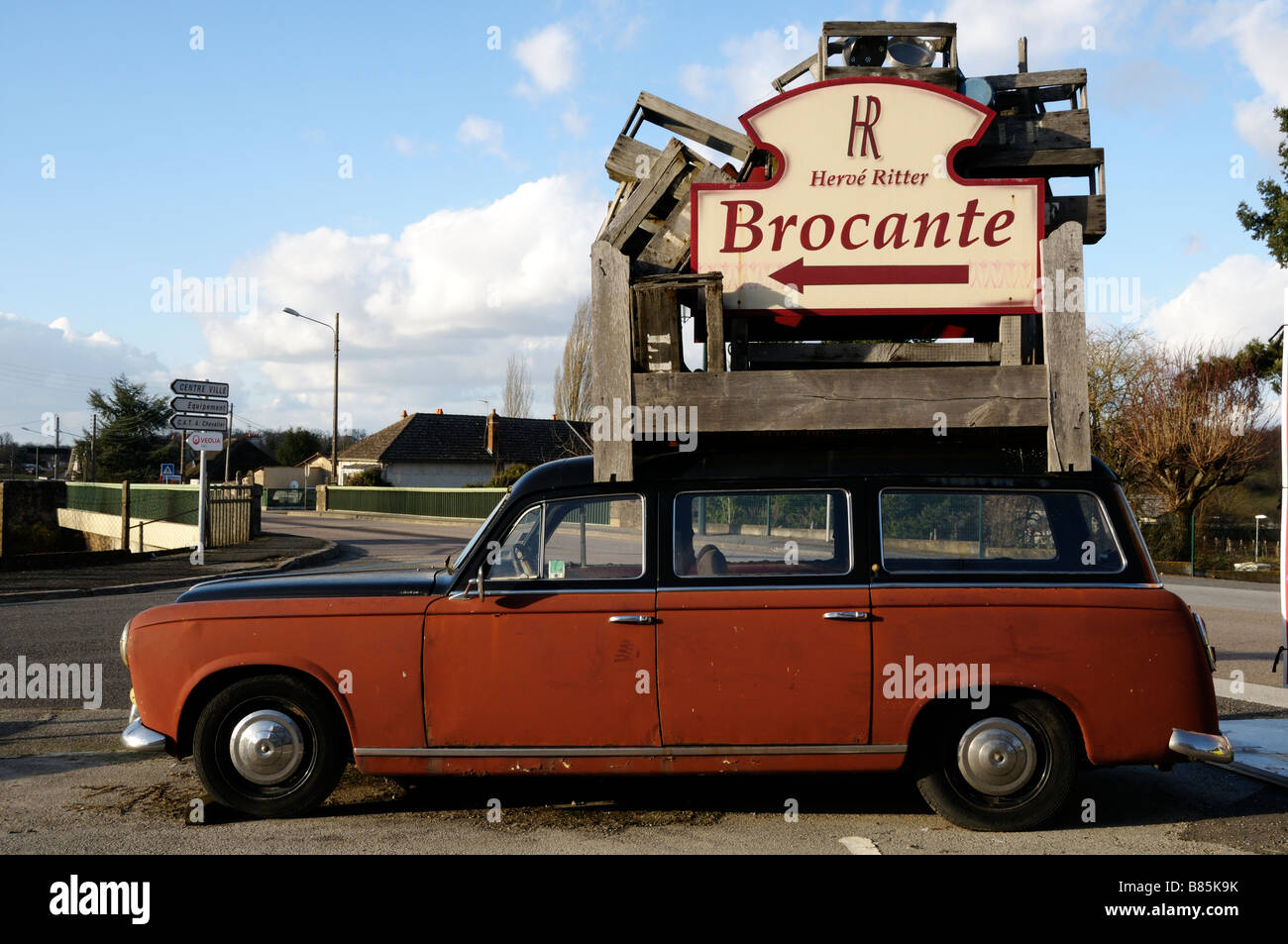 Stock photo of an old Peugeot 403 piled high with bric a brac The car is advertising a local Brocante shop in Bellac France Stock Photo
