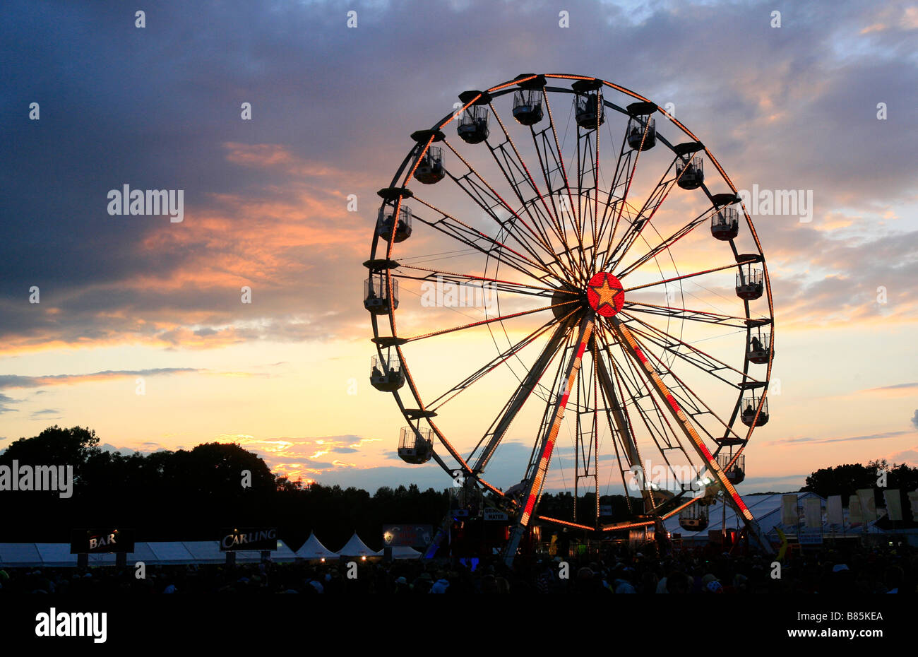 The sun sets behind a ferris wheel at the 2008 Isle of Wight festival on the Isle of Wight, United Kingdom. Stock Photo