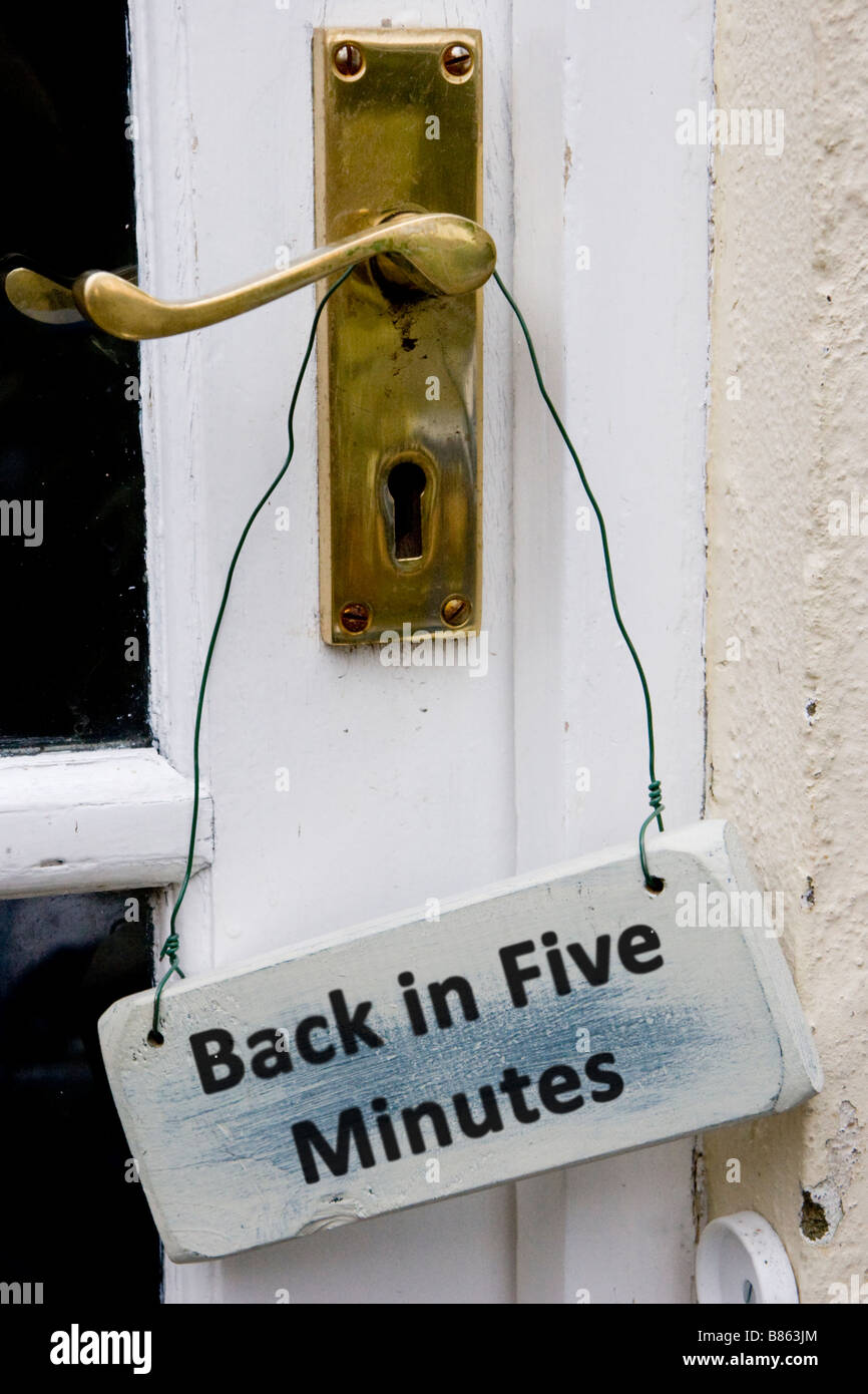 Back in five minutes sign on a door handle Stock Photo