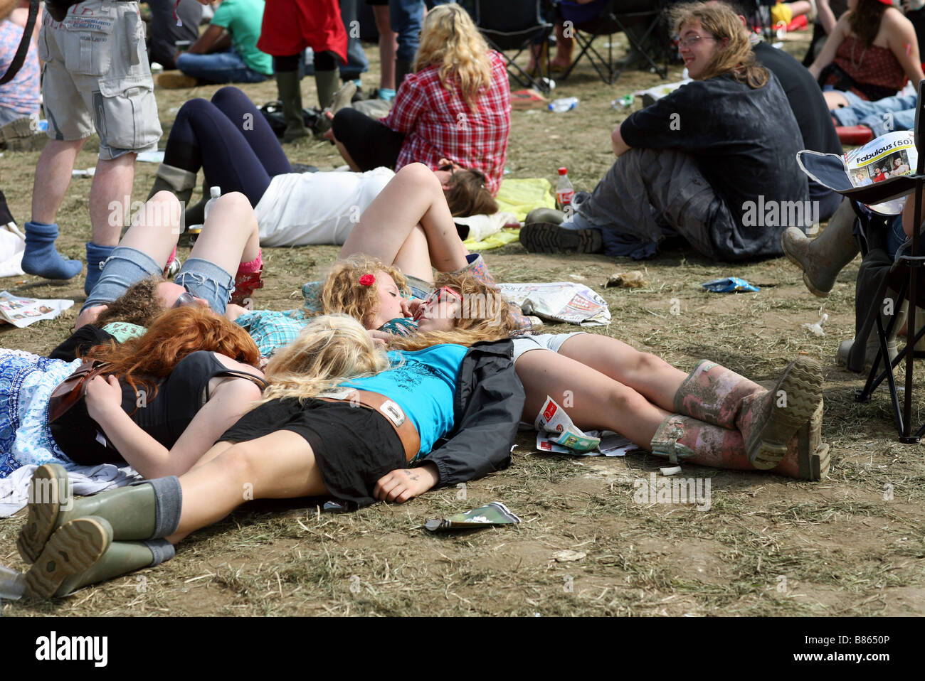 A group of girls lies in the dried mud at the 2008 Glastonbury festival in Pilton, Somerset in the UK. Stock Photo
