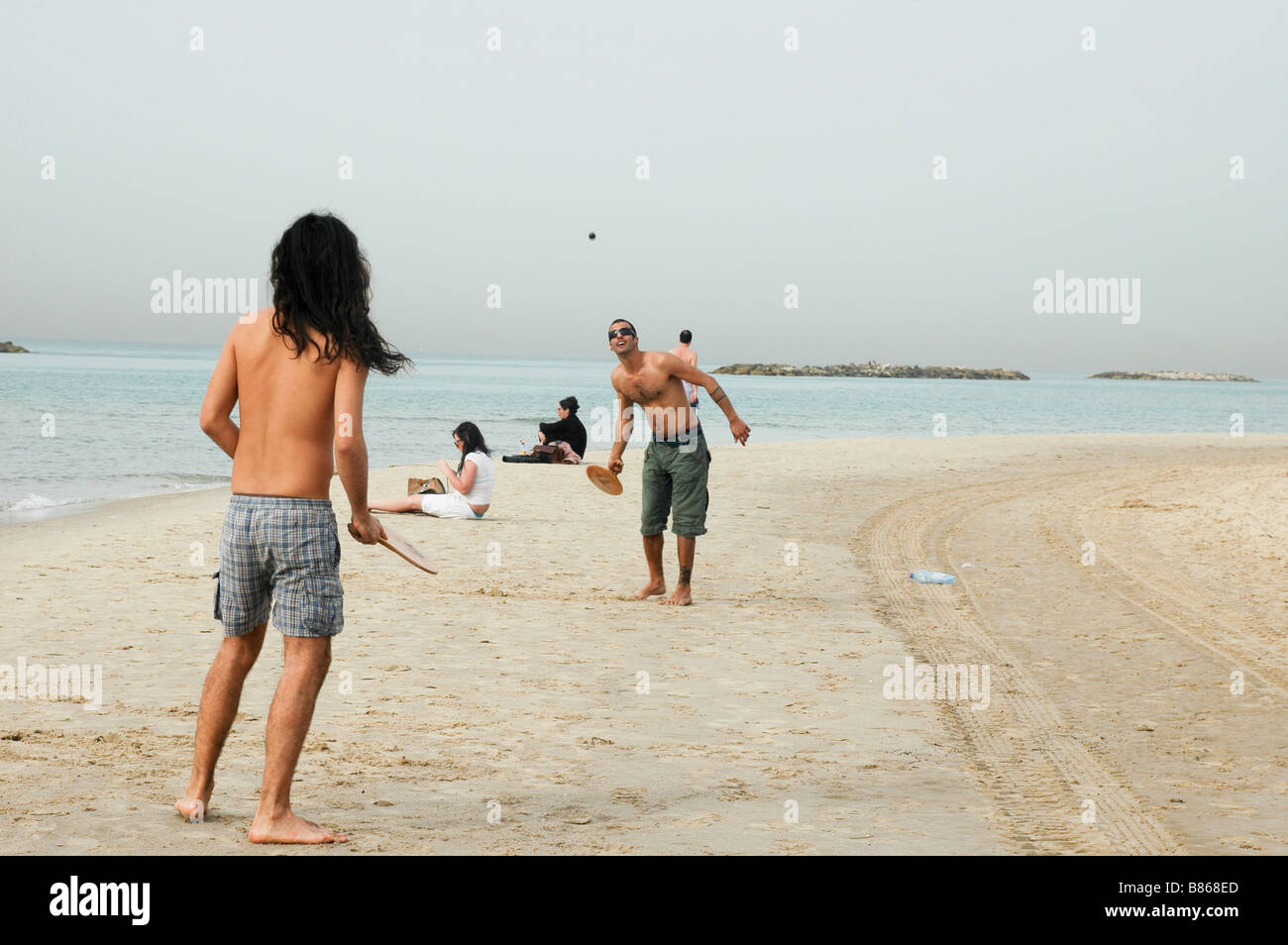 Israel Tel Aviv Two young men playing with a bat and ball AKA Matkot on the beach Stock Photo