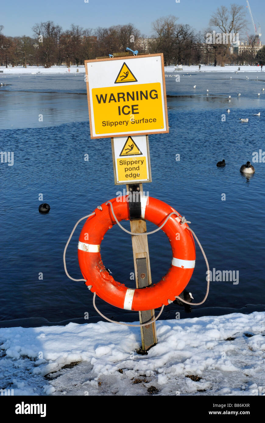 Warning sign for ice on frozen lake Stock Photo