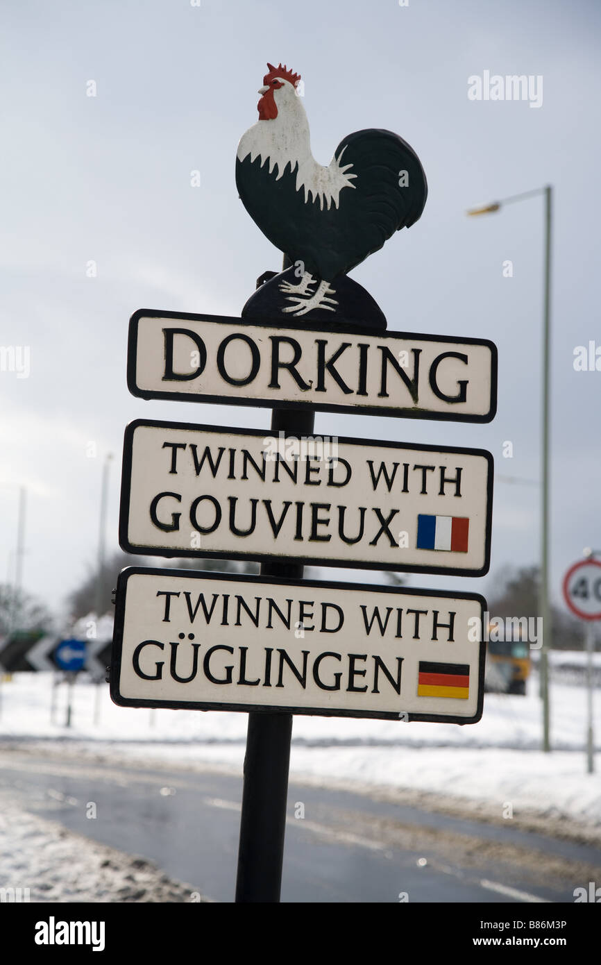 A leaning sign on the approach to Dorking town, Surrey, UK, depicting the Dorking cockerel and