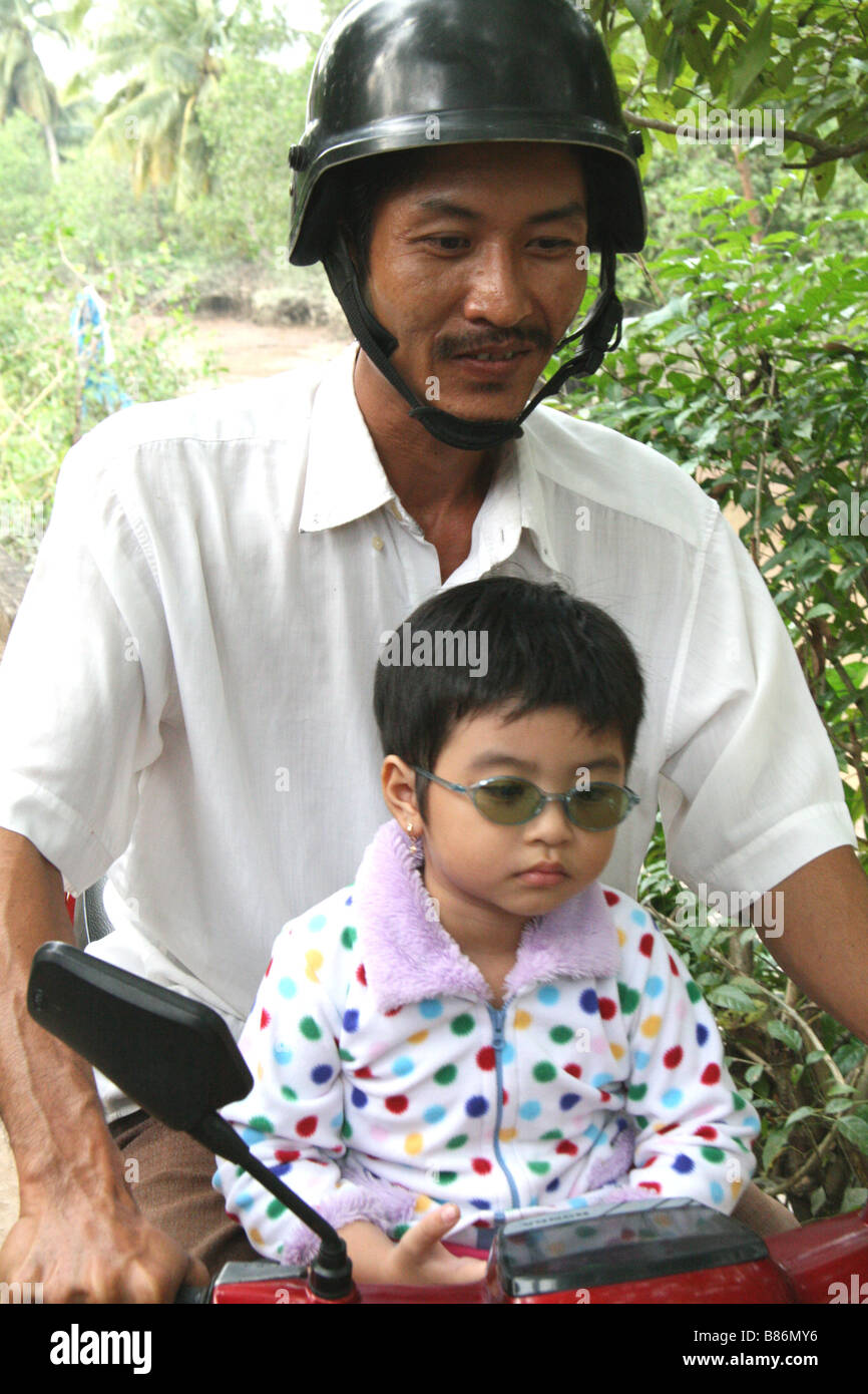 Picture of a pretty, young Vietnamese girl with glasses and her father (taken in a village in Vietnam) in the Mekong Delta Stock Photo