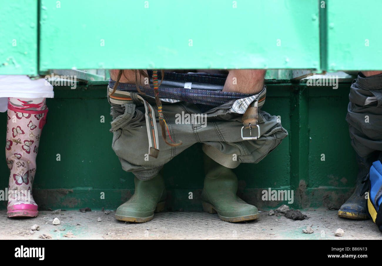 A person uses the loo at the 2008 Glastonbury festival in Pilton, Somerset in the UK. Stock Photo