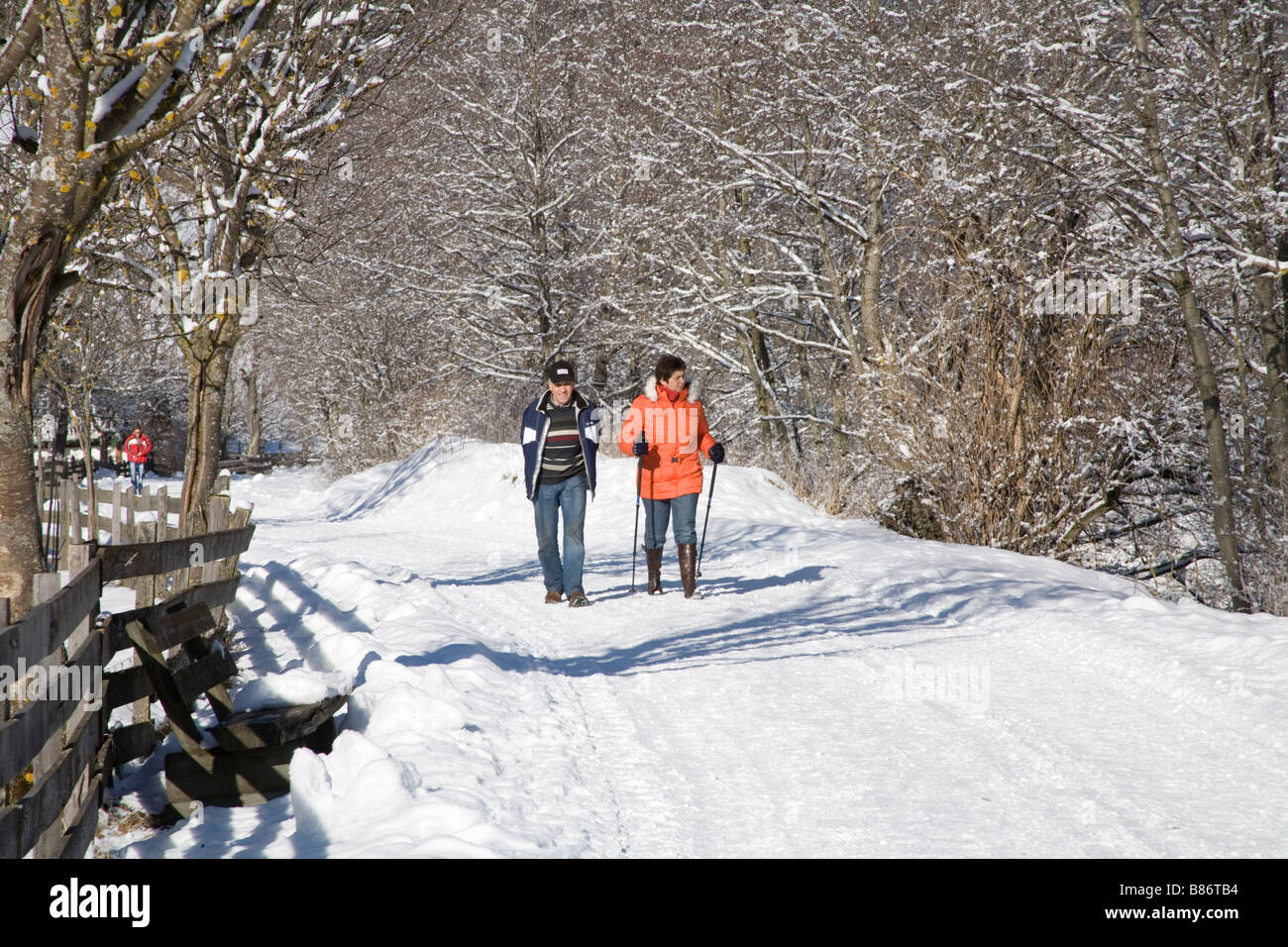 Pinzgau Region Austria EU January A woman and a man walking along a Winterwanderweg a cleared walking path Stock Photo