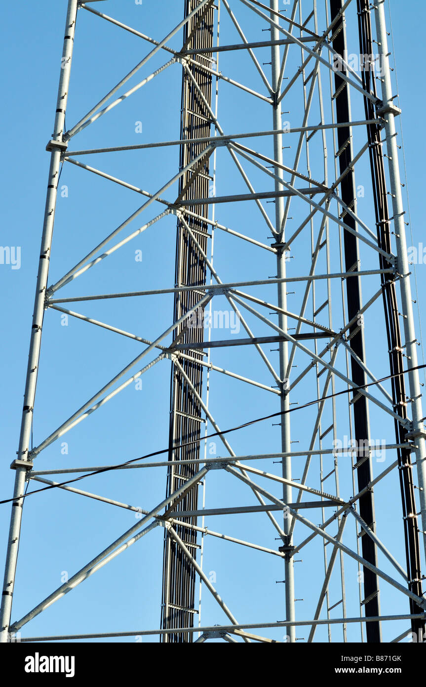 Detail of metal grid work on cell phone mobile tower with cables going up ladder and many angles USA Stock Photo
