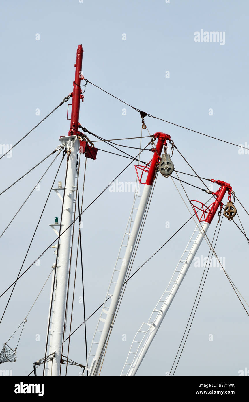 Pulley setup with block and tackle on booms connected to masthead with lights on bow of commercial fishing boat Stock Photo