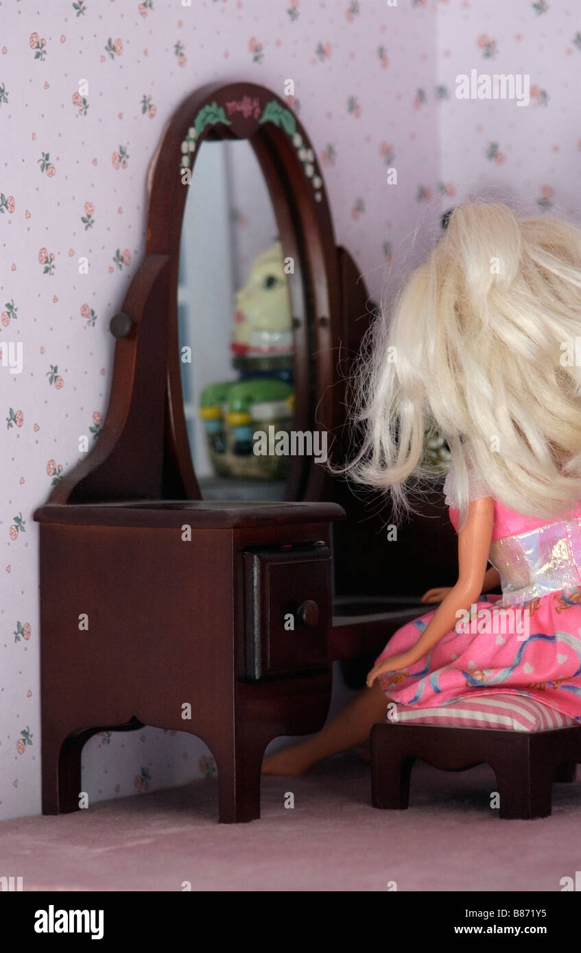 barbie doll sitting at vanity with humpty dumpty reflected in mirror Stock Photo