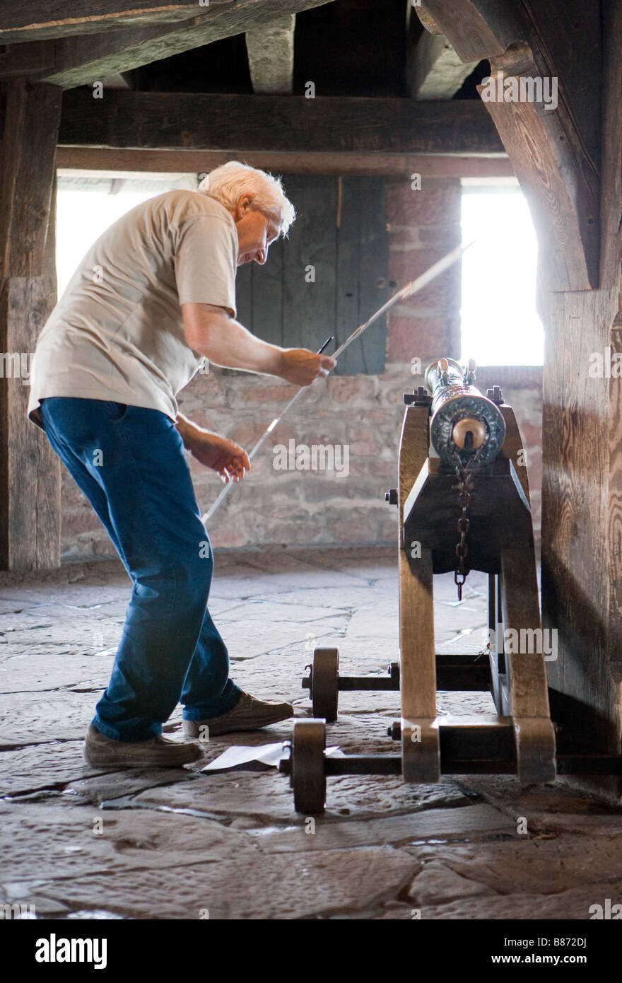 Visitor studies the cannon in the castle Haut Koenigsbourg Stock Photo