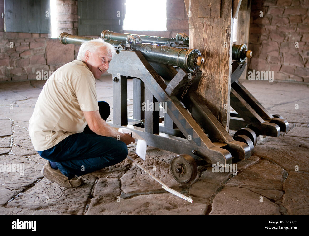 Visitor studies the cannon in the castle Haut Koenigsbourg Stock Photo