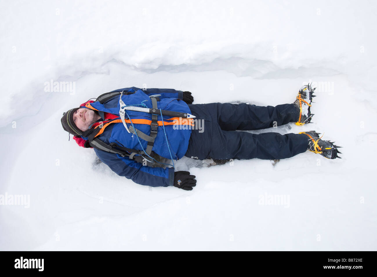 A man lying in the snow on Crinkle Crags in the Lake District UK Stock Photo