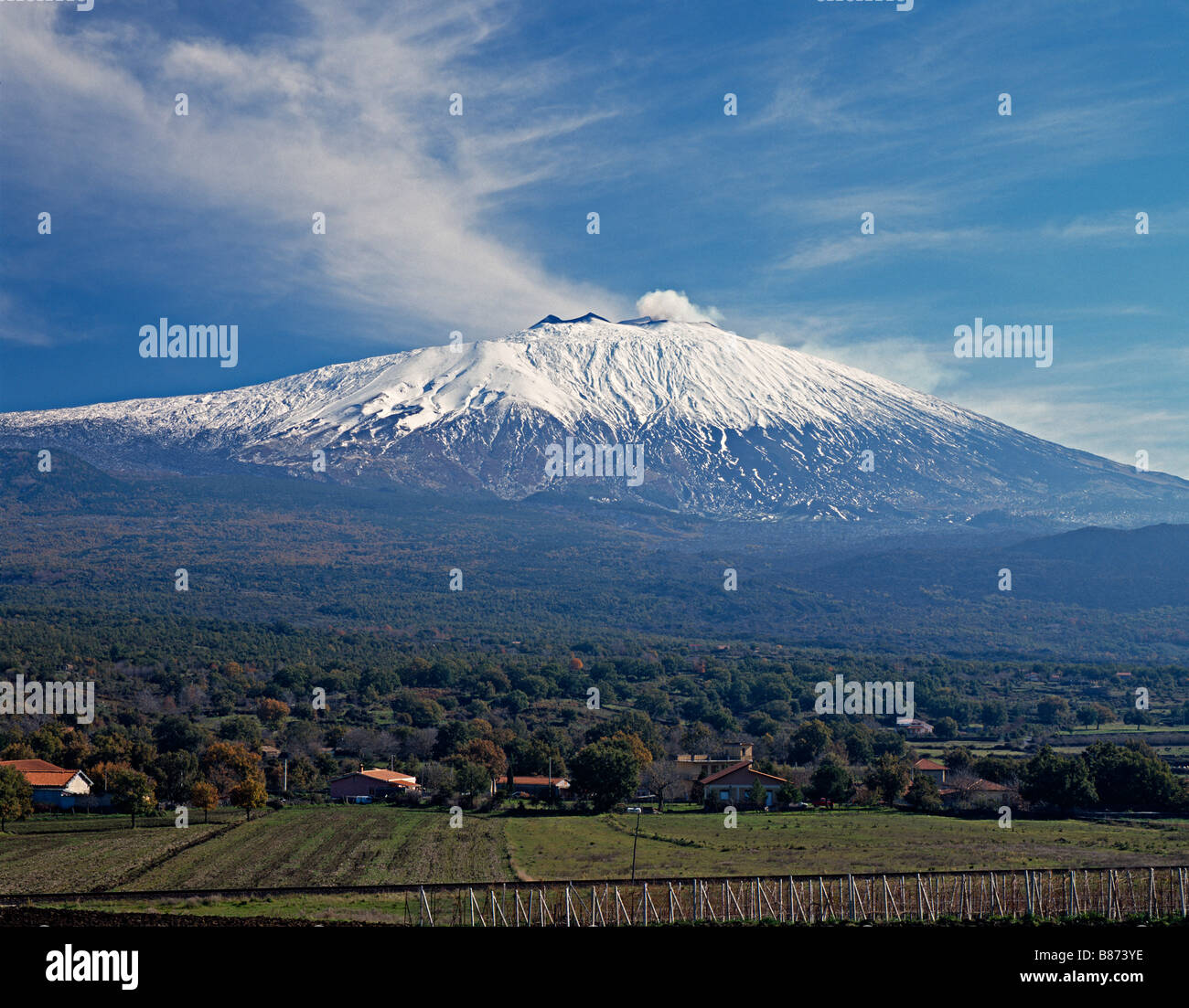 Mount Etna, Sicily, Italy, towers above the many farms and vineyards making use of its fertile volcanic soil Stock Photo