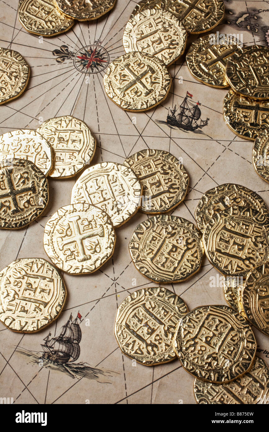 Gold coins doubloons on very old map Stock Photo