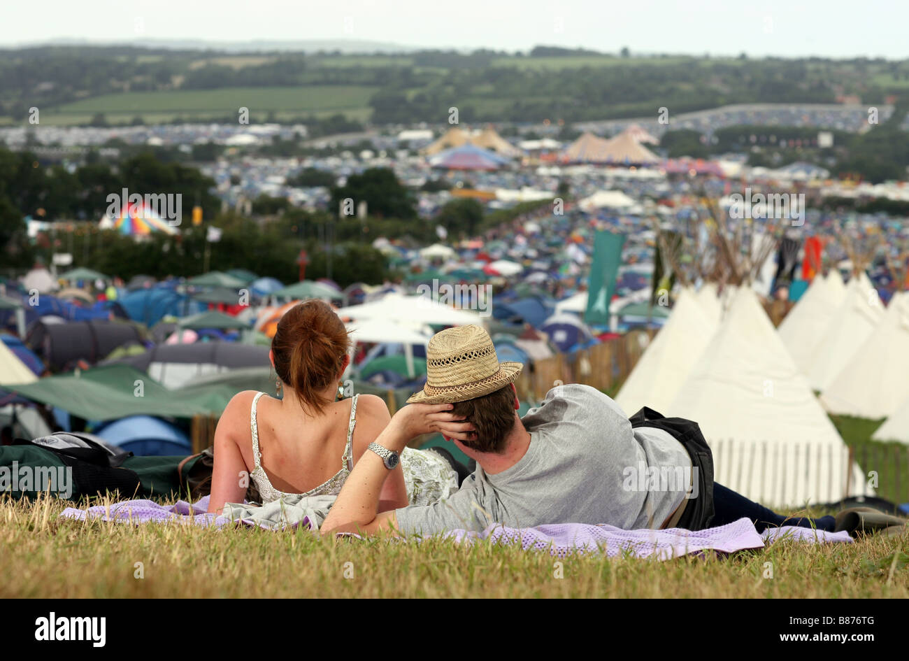 A couple sit on a rug as they admire the view across the 2008 Glastonbury Festival in Pilton, Somerset in the UK. Stock Photo