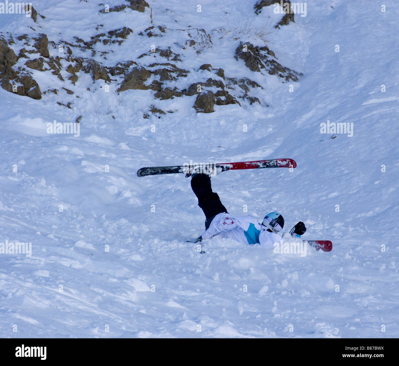 Fallen skier with one leg in the air in a humerous position Stock Photo