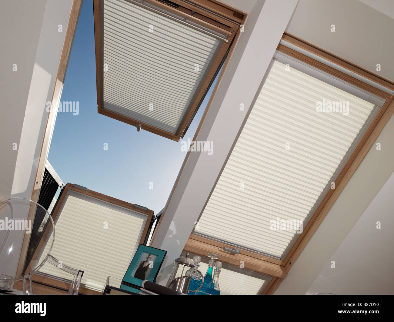 two large velux windows with blinds one opened up Stock Photo