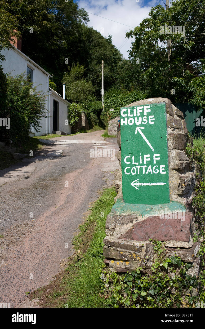 On a slope in Laugharne Carmarthenshire South Wales signs painted in green point to cliff house and cliff cottage Stock Photo