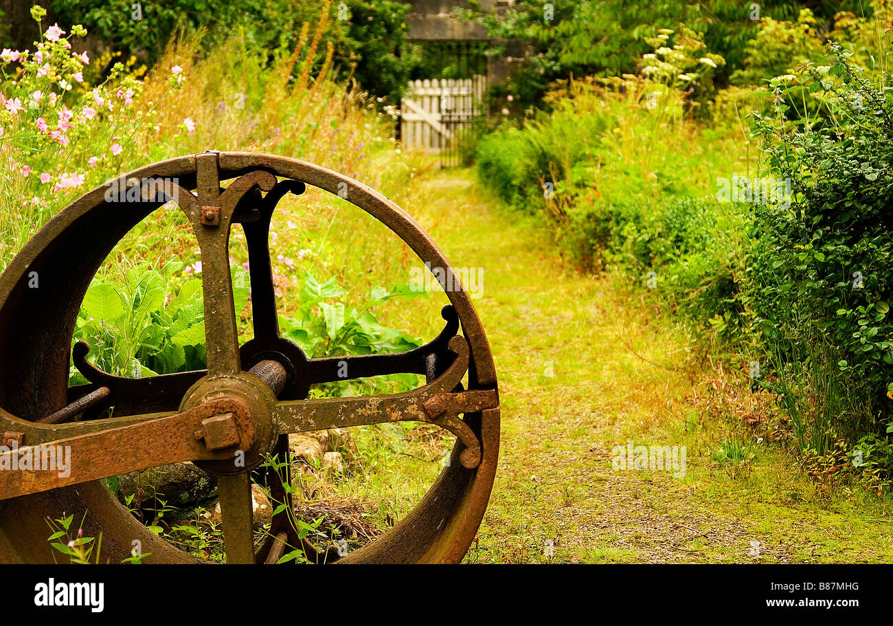 path to a secret garden with ancient iron roller in foreground Stock Photo