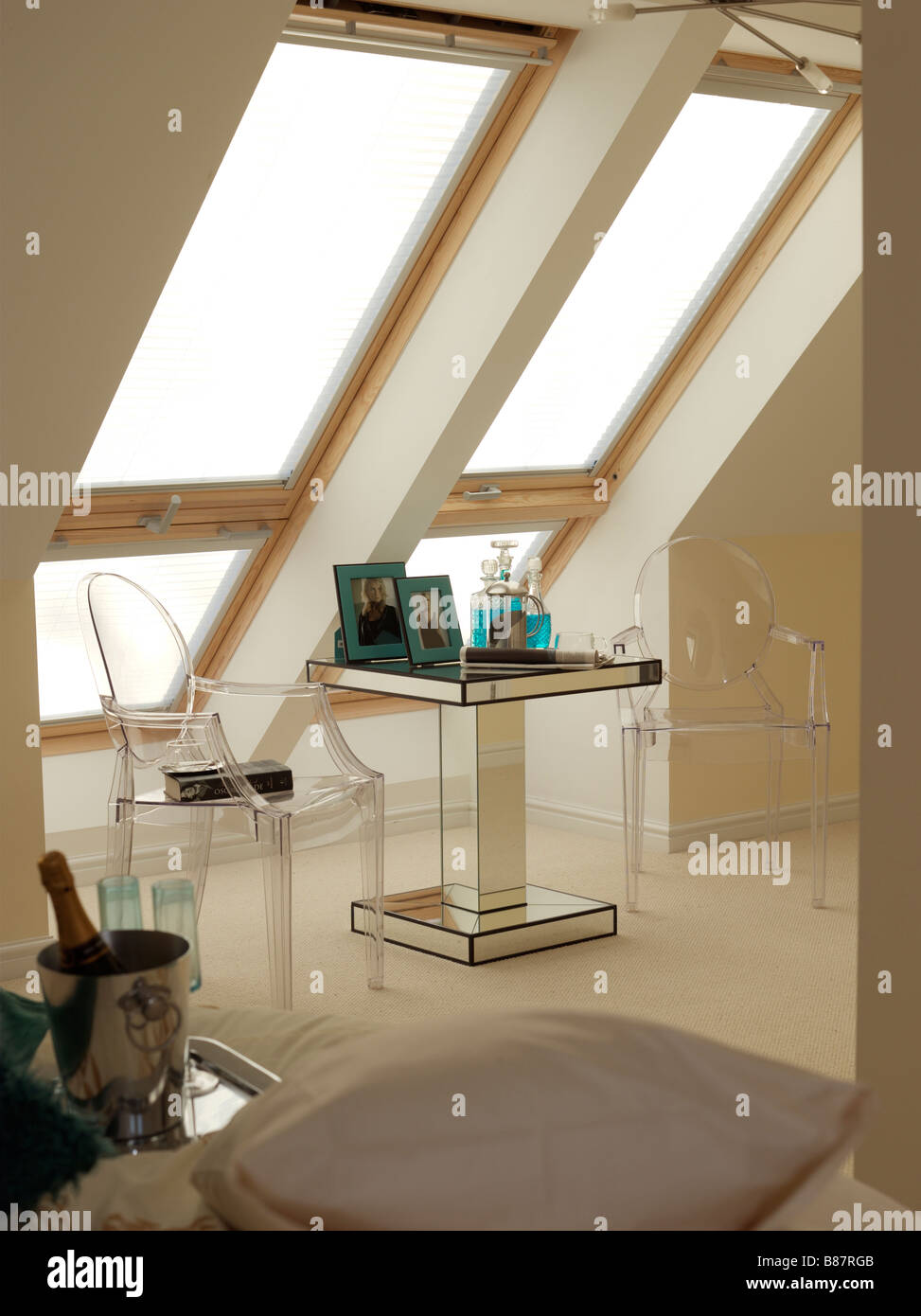 large velux windows with small table and two chairs with champagne and glasses Stock Photo