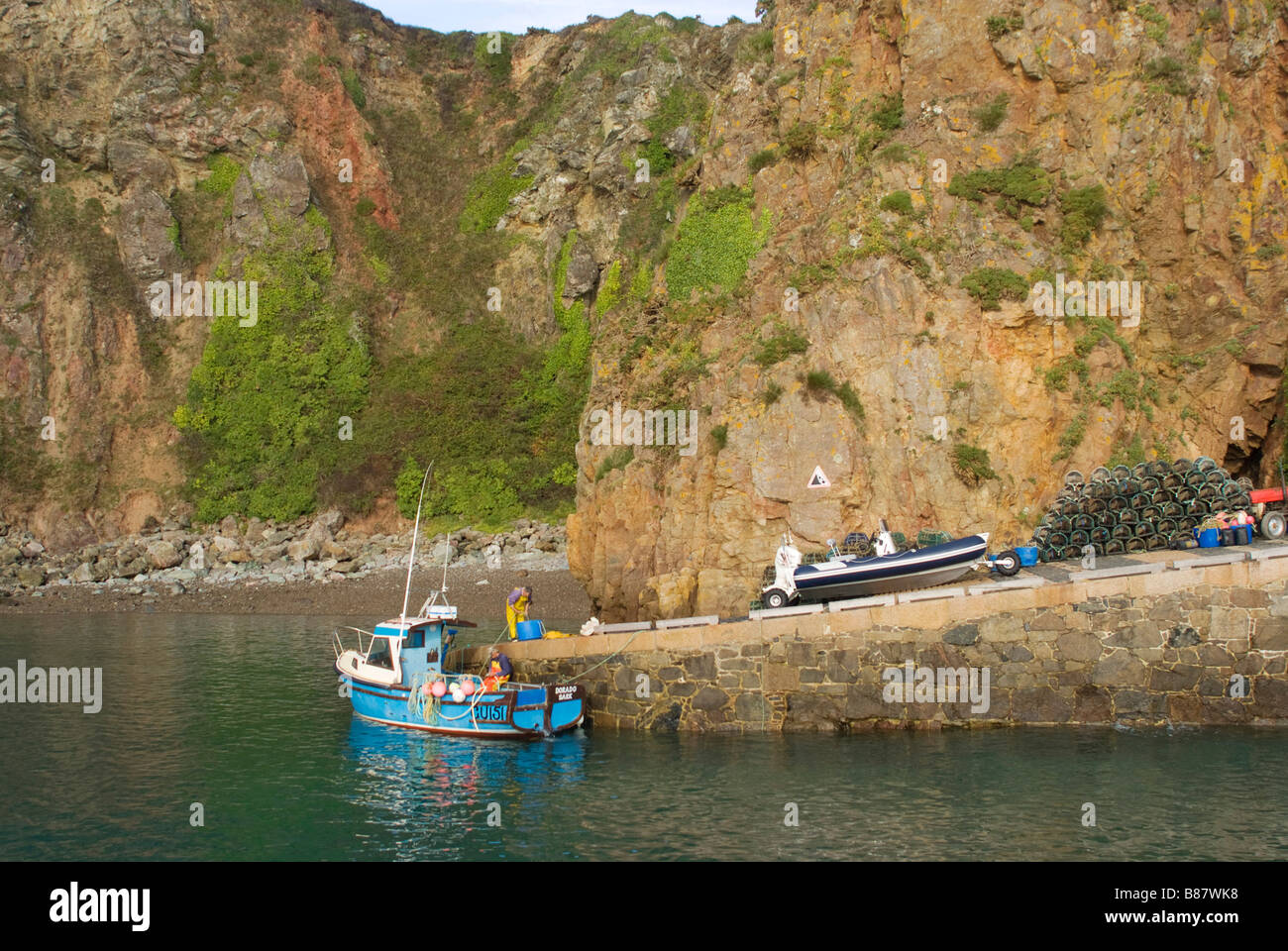 Cliff drop Old Harbour Sark slip way into sea water incoming boat Stock Photo