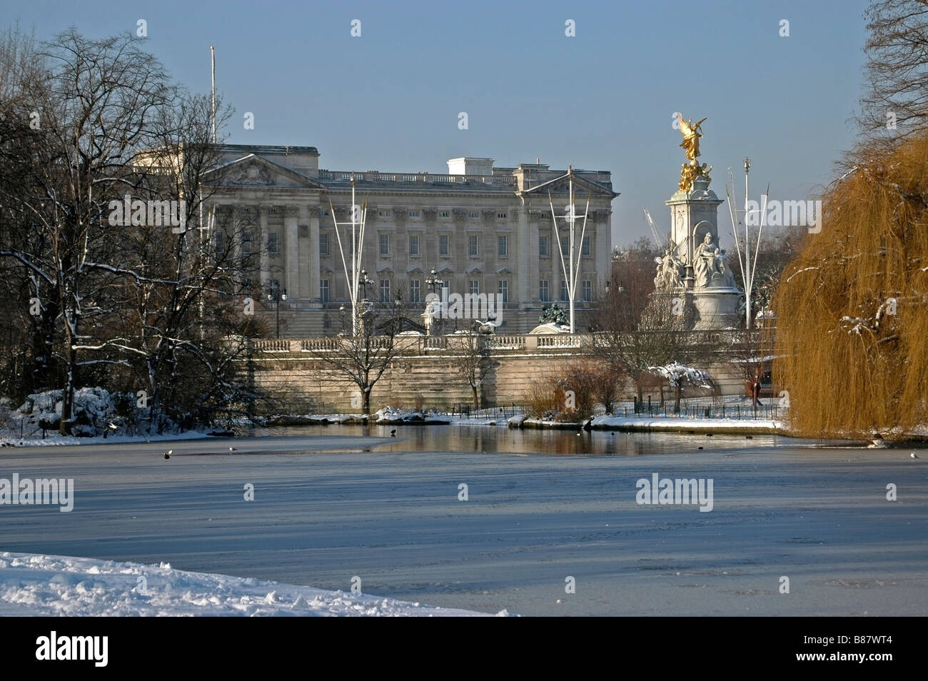View from St James Park across the lake to Buckingham Palace And the Queen Victoria Memorial in Winter snow. Stock Photo