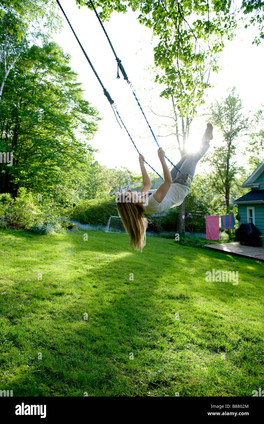 Young woman swinging in her backyard Stock Photo - Alamy