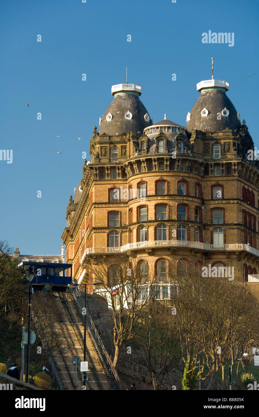 Decorative cornice and slate tiled cupolas of the curved facade of The Grand Hotel, with St Nicholas Cliff lift to the left. UK Stock Photo