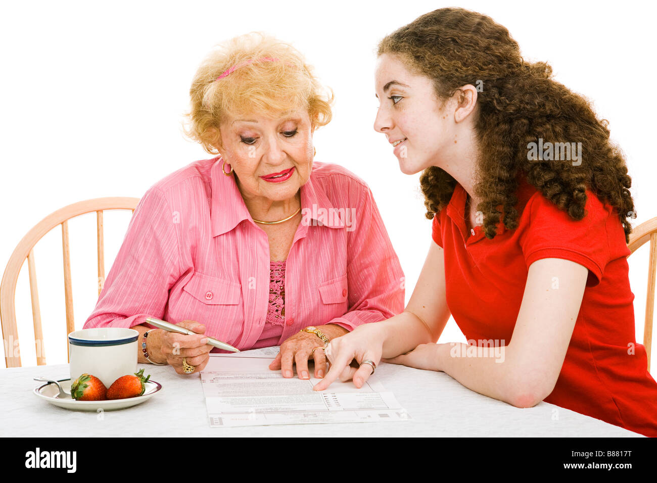 Senior woman filling out absentee ballot with help of her granddaughter ...
