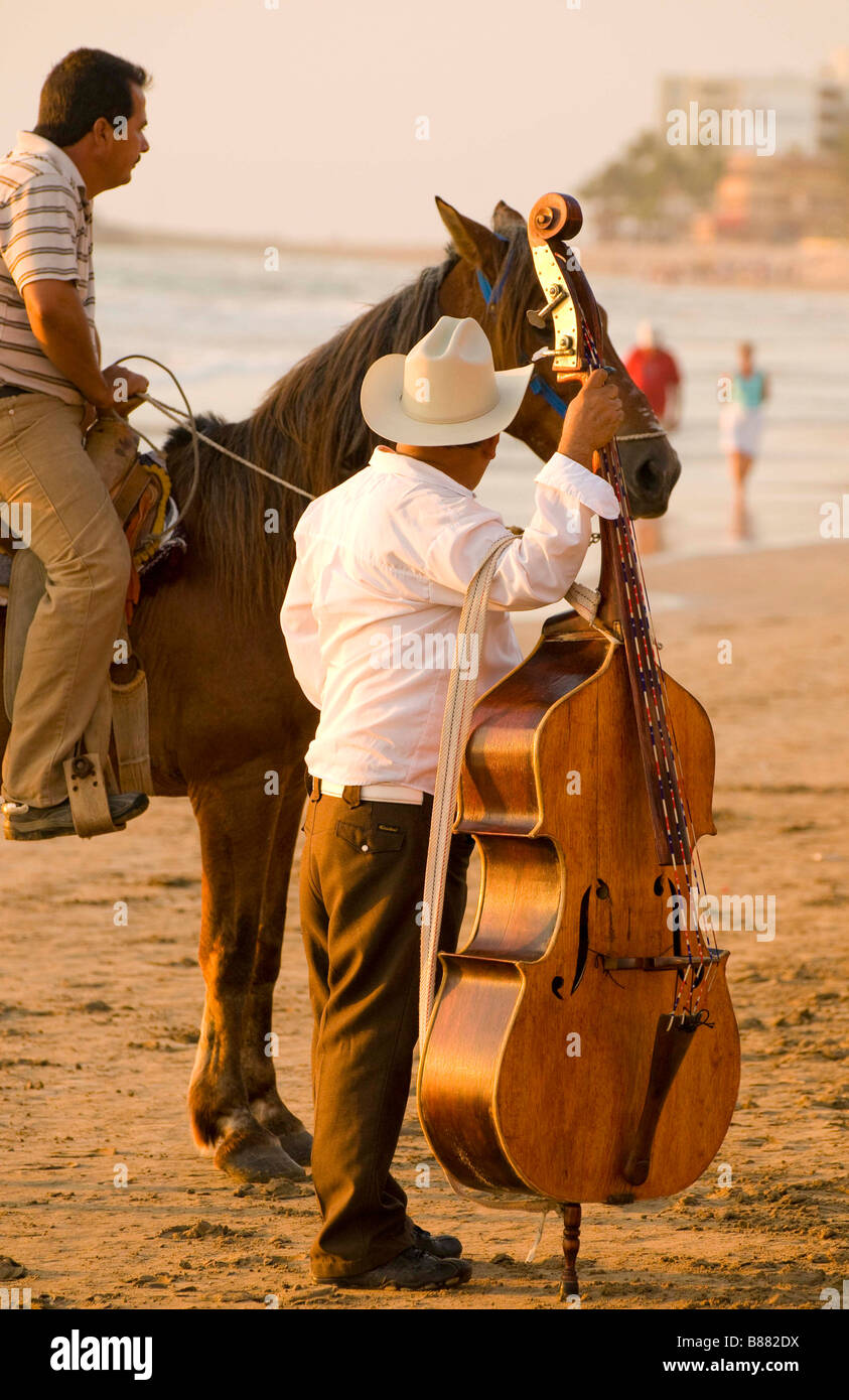 MEXICO SINOLA STATE MAZATLAN Base musician on beach talking with man riding horseback. Golden Zone Stock Photo