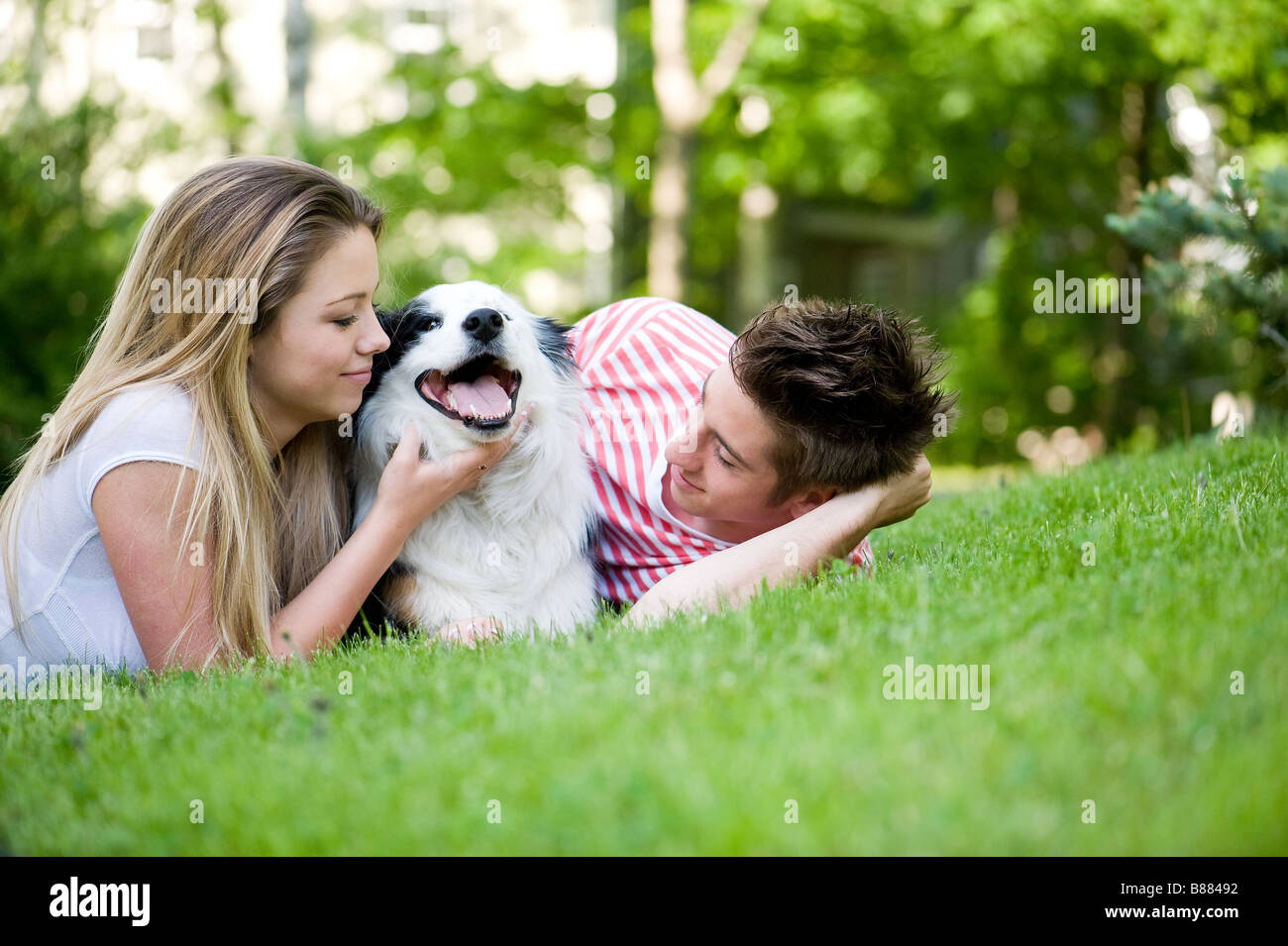 Couple playing with their dog outside Stock Photo - Alamy