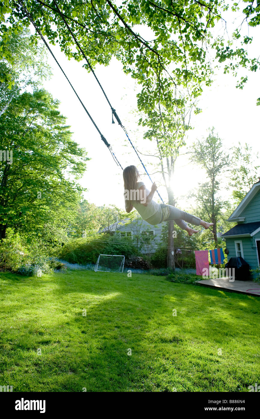 A young girl swinging in her backyard Stock Photo - Alamy
