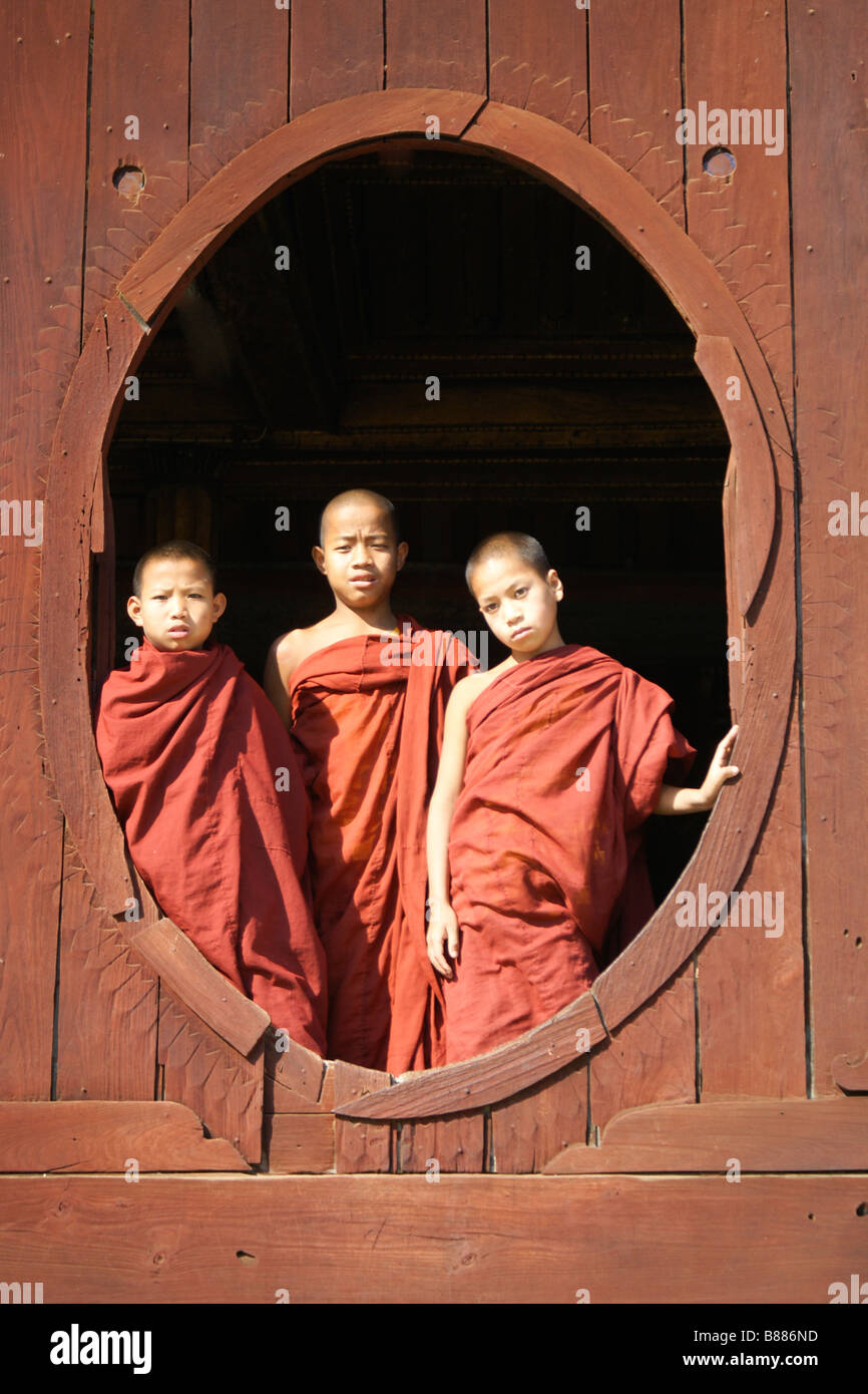 Young Buddhist monks in window of Shwe Yan Pye monastery, Inle Lake, Myanmar (Burma) Stock Photo