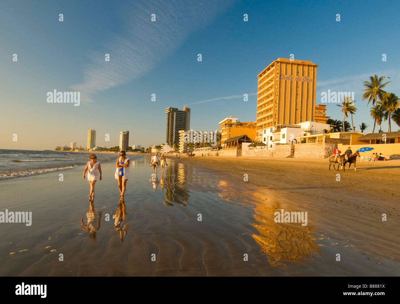 MEXICO SINOLA STATE MAZATLAN People enjoying outdoor activities and riding horses along the beach Golden Zone Stock Photo