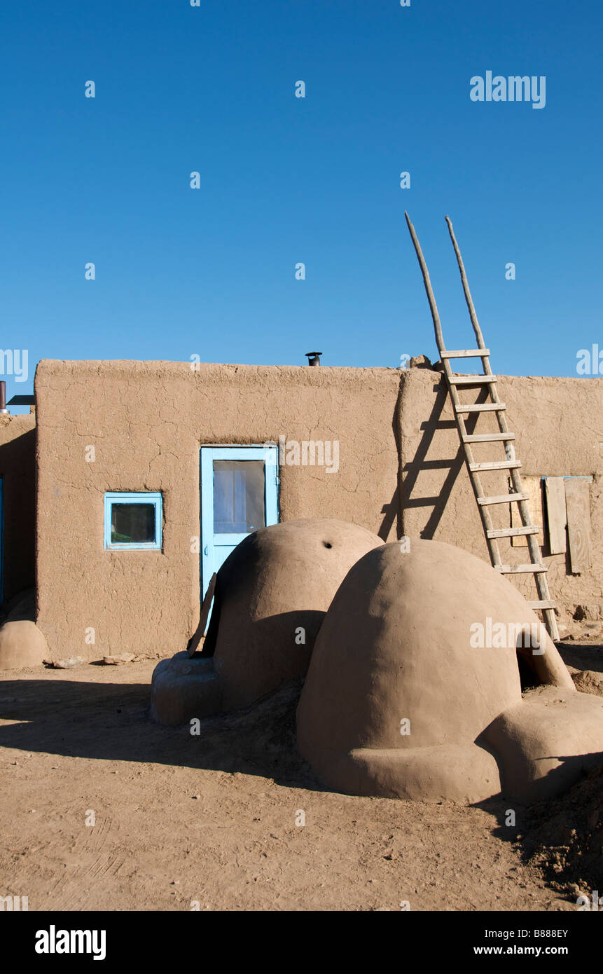 Inhabited adobe house with two beehive earthen ware ovens Taos Pueblo New Mexico USA Stock Photo