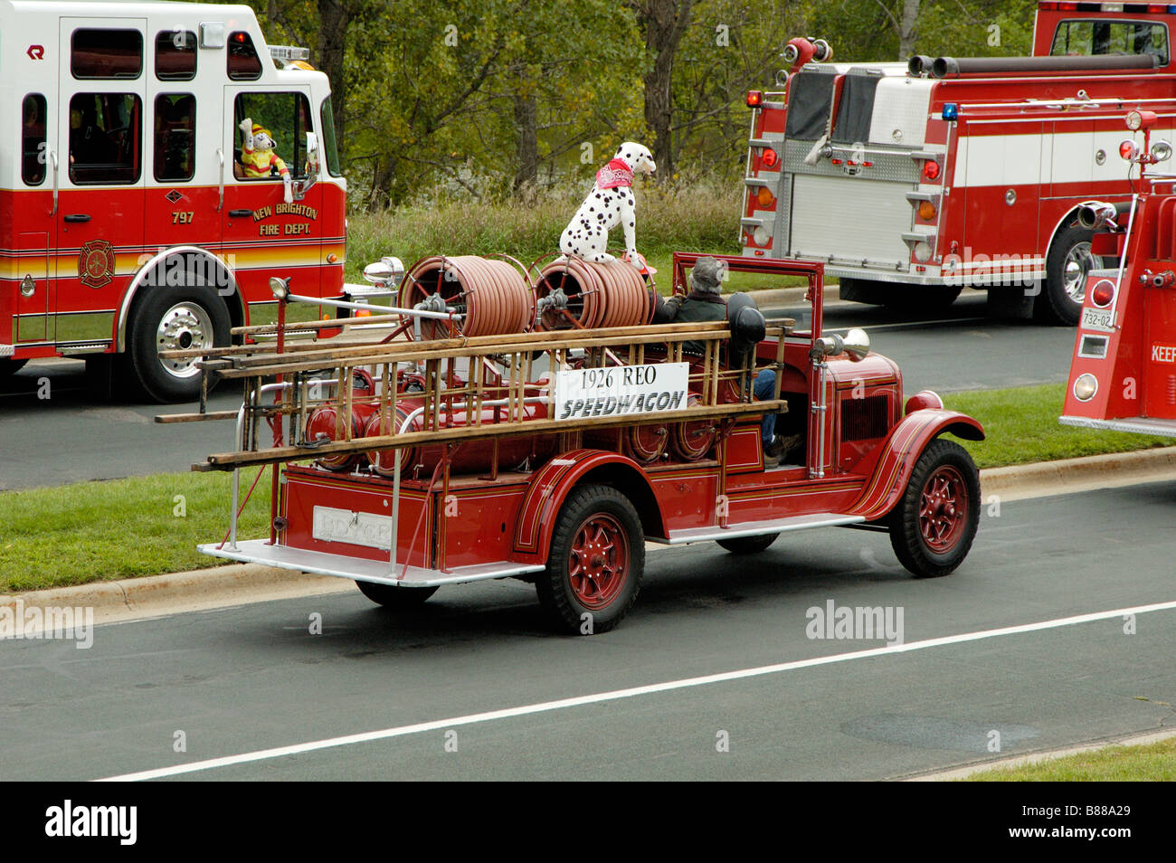 An antique fire department vehicle being driven in a fire muster parade Stock Photo