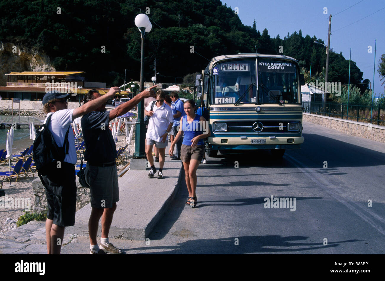 Bus People standing with arms out hailing bus CORFU TOWN CORFU GREECE