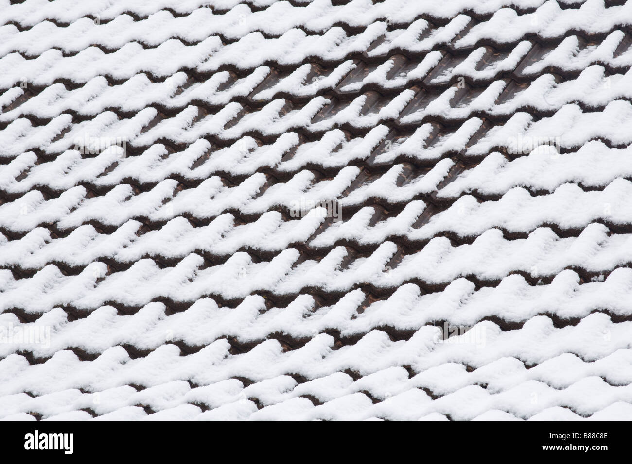 brick tiled roof with sprinkling of snow, a rarity on the coast of South Wales Stock Photo