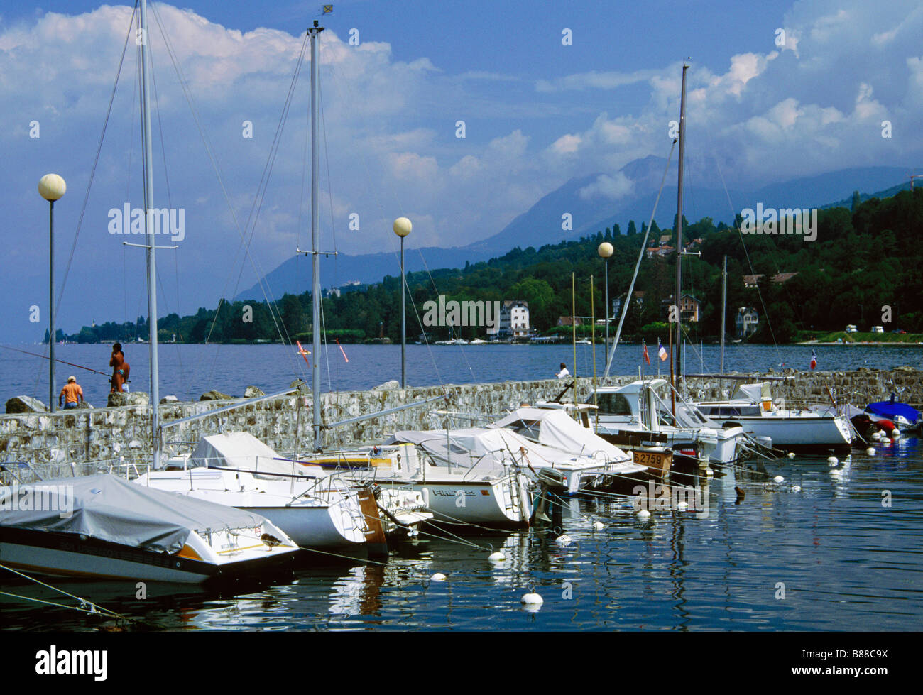 Boats moored against stone wall  Lac LemanmLake Geneva  Haute-Savoie AMPHION-LES-BAINS RHONE VALLEY FRANCE Stock Photo