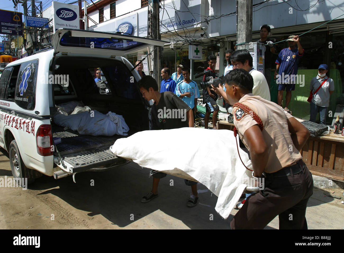 Emergency personnel pick up a body off the road at Patong Beach on