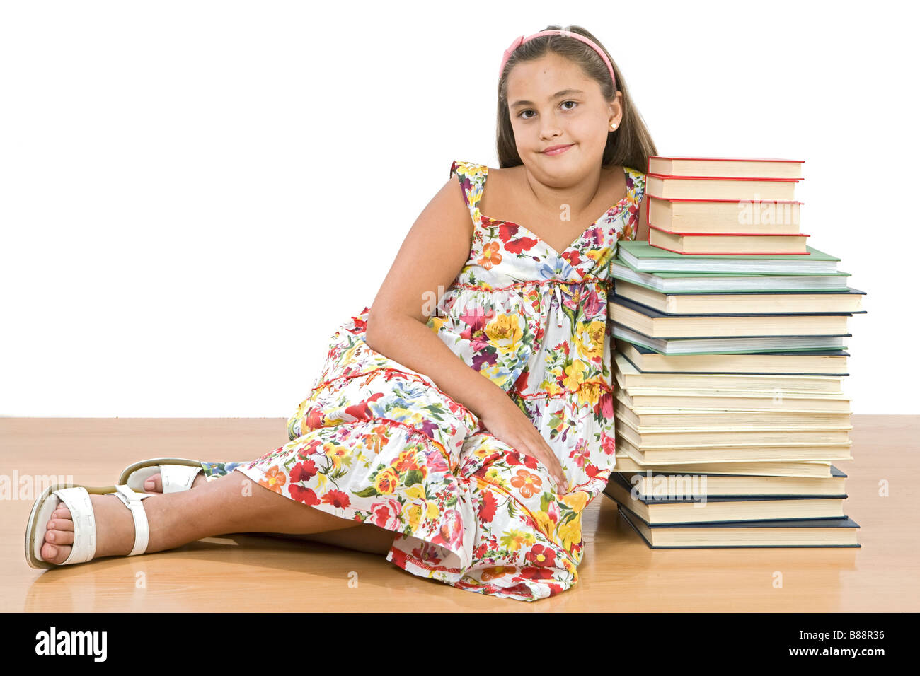 Adorable girl with many books sitting on wooden floor Stock Photo - Alamy