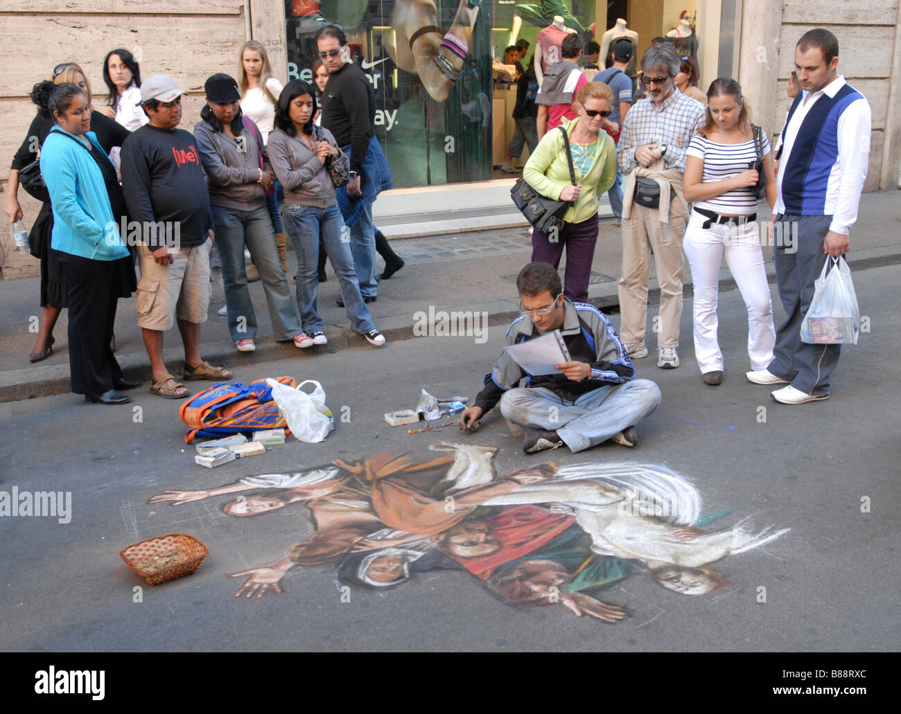 Pavement artist doing a copy of a religious painting in pastel on a street in Rome Italy Stock Photo